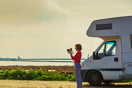 Woman on caravan trip taking travel photos with camera. Las Salinas Cabo de Gata Nijar Natural Park, Andalusia Spain. Tourist attractionの写真素材