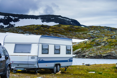 Camper trailer camping on lake in mountains landscape. Norwegian national tourist scenic route Sognefjellet.の写真素材