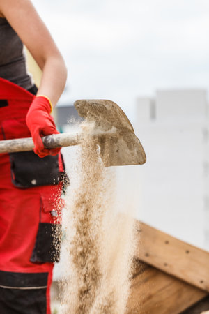 Unrecognizable person worker using shovel standing on industrial construction site, working hard on...