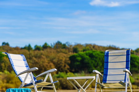 Two empty folding camp chairs outdoors on nature. Holidays, relaxation on open air. Vacation in the camping,の写真素材