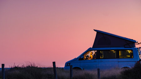 Camper van with roof top tent camping on mediterranean coast. Holidays and travel in motorhome.