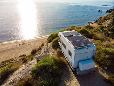 Aerial view. Caravan with solar photovoltaic panels on roof camping on cliff sea coast. Mediterranean region of Villaricos, Almeria, eastern Andalusia, Spain.の写真素材