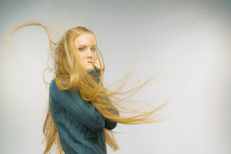Sad melancholy young woman with blowing long blonde hair.の写真素材