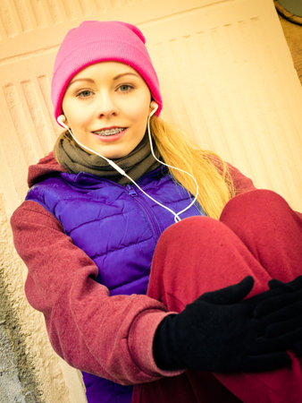 Outdoor sport exercises, sporty outfit ideas. Woman wearing warm sportswear relaxing after...