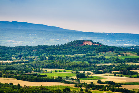 Red rocks of Colorado provencal in Roussillon, Plateau de Vaucluse, Provence in France. View from distance. Summer landscape.の写真素材