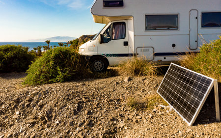 Caravan with portable solar panel camping on sea coast. Holidays in winter time. Mediterranean...