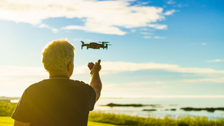 Start the drone, launching from hands. Modern small copter with camera in user hand, against nature....