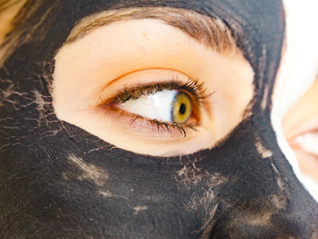 Skin care. Woman with charcoal facial mask, deep black cleanser on face. Beauty, spa and acne treatment.の写真素材