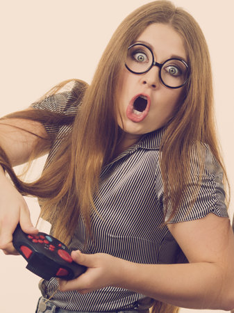 Young adult woman playing on the video console holding pad being very into game. Gaming gamers...
