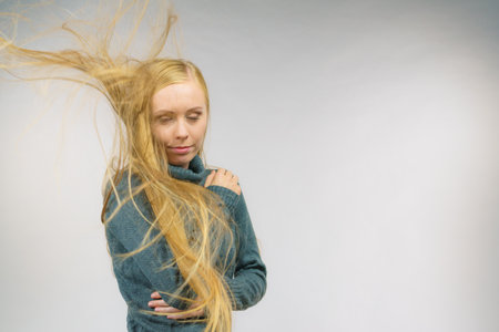 Young female with long hair flying around her face.の写真素材