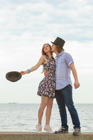Summer happiness love relationship and dating concept. Young romantic playful couple flirting on nature, guy kissing his girlfriend.の写真素材