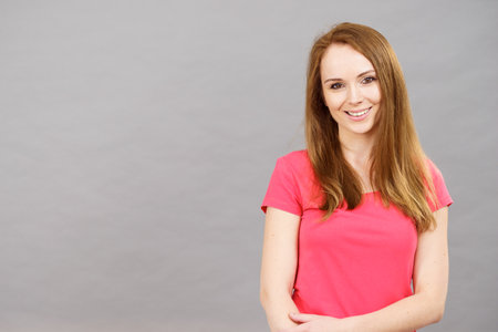 Portrait of young brunette woman, studio shot on greyの写真素材