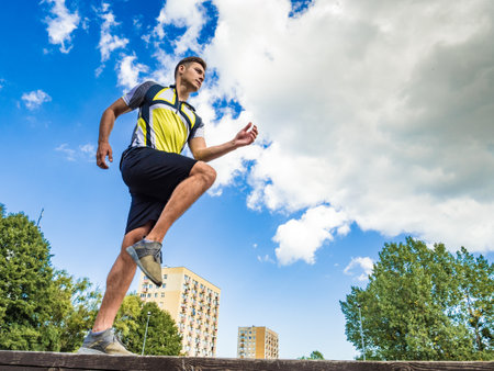 Young handsome guy in sportswear suit running outdoors in park. Botton viewの写真素材