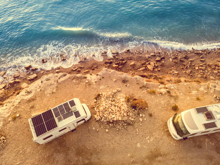 Two caravans with solar panels on roof camping on coastal cliff. Mediterranean sea in Spain.の写真素材