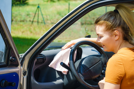 Woman cleaning car interior dashboard with cloth.の写真素材