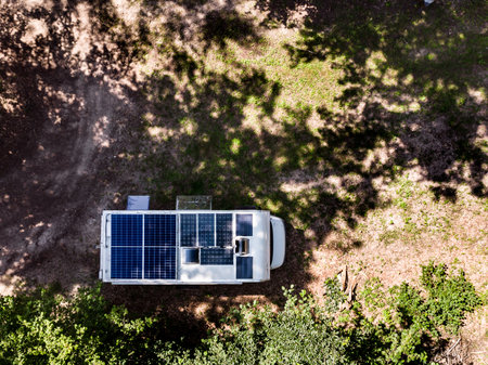 Aerial view. Camper rv with solar photovoltaic panels on roof camping on nature. Caravan vacation.の写真素材