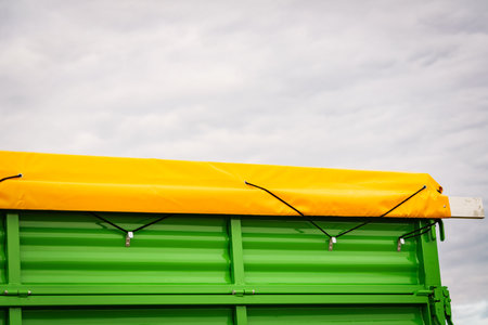 Yellow tarp tarpaulin fastened with rope to trailerの写真素材