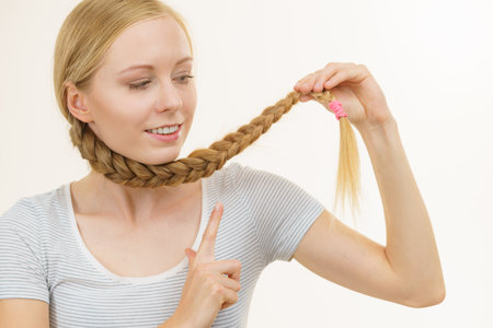 Blonde young woman with long braid hair around the neck. Braided hairstyles.の写真素材