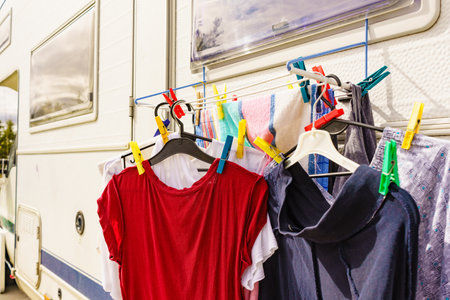 Clothes clean washing laundry hanging to dry on clothesline outdoor, caravan in the background. Camping, adventure conceptの写真素材