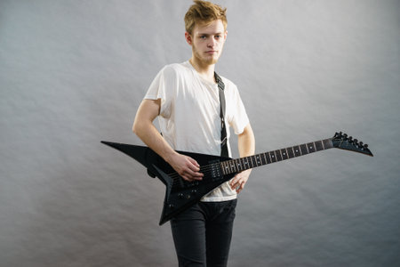 Man playing on electric guitar during gig. Musical instrument. Teenage boy having music hobby.の写真素材