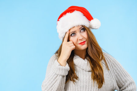 Thinking christmas woman, female gesturing with hand seeking for solution, having contemplating face expression. Thought process.の写真素材