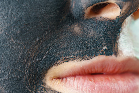 Skin care. Woman with charcoal facial mask, deep black cleanser on face. Beauty, spa and acne treatment.の写真素材