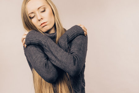 Sad worried young female. Huddled girl feels unhappy, problem in personal life, heartbreak. Mental illness.の写真素材