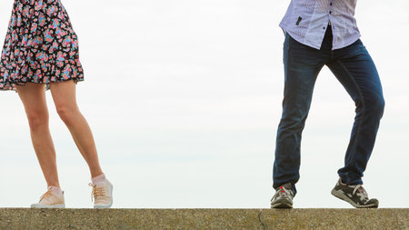 Couple turned away from each other. Young male and female going in different directions. Concept of disagreement, misunderstanding, separation, crisis in relationshipの写真素材