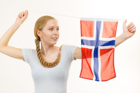 Blonde young woman teen girl braid hair holds norwegian flag. Scandinavian people.の写真素材