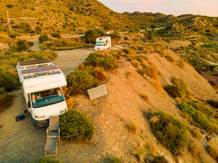 Aerial view. Caravan rv vehicle with solar photovoltaic panels on roof camping on sea cliff. Mediterranean region of Villaricos in Almeria, eastern Andalusia, Spain.の写真素材