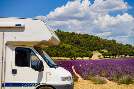 Camper vehicle camping on summer nature at lavender blooming purple field in France. Holidays, vacation with mobile home.の写真素材