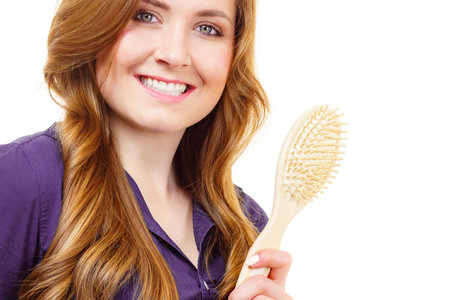 Young woman brushing long healthy brown hair, using hairbrush. Haircare.の写真素材