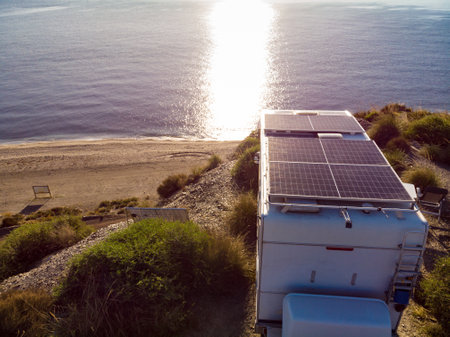 Aerial view. Caravan with solar photovoltaic panels on roof camping on cliff sea coast. Mediterranean region of Villaricos, Almeria, eastern Andalusia, Spain.の写真素材
