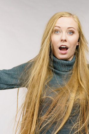 Surprised young woman, female with long blond hair.の写真素材