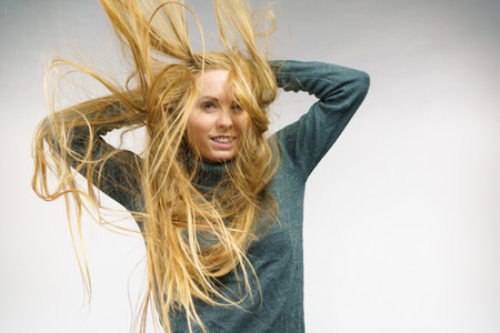 Young female with long hair flying around her face. Haircare concept.の写真素材
