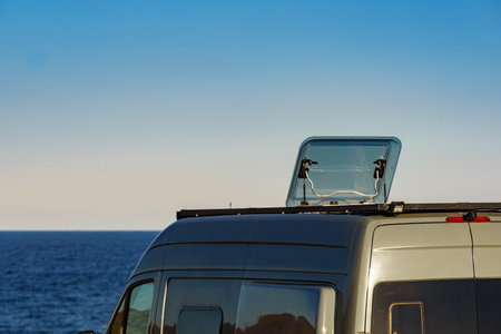 Sunroof, raisable panel window on roof top of rv camper van against blue sky. Traveling by motor home.の写真素材