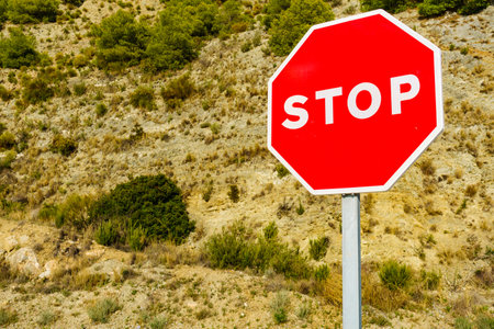 Traffic stop red sign by the road in mountainsの写真素材