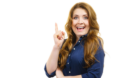 Young thinking woman having idea moment pointing finger up. Eureka creativity conceptの写真素材