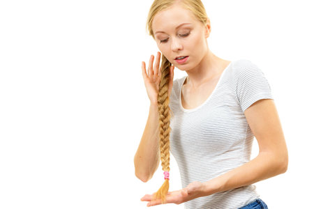 Blonde girl with long braid hair. Haircare, hairstyling, feminine style.の写真素材