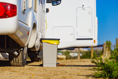 Trash can with plastic bag inside in front of caravan. Holidays and travel in motorhome.の写真素材