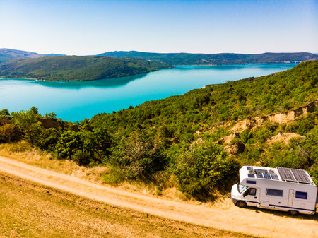 Camper with solar panels on roof camping at Sainte Croix Lake, Verdon Gorge in french Alps mountains, Provence France. Holidays trip.の写真素材