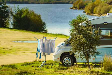 Camping on nature, road trip. Laundry clothes hanging to dry outdoor by camper car.の写真素材
