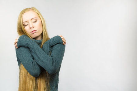 Sad worried young female. Huddled girl feels unhappy, problem in personal life, heartbreak.の写真素材