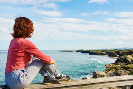 Tourist woman enjoying sea coast landscape, visiting Cathedral Beach in Galicia Spain. Playa de las Catedrales, As Catedrais in Ribadeo, province of Lugo.の写真素材