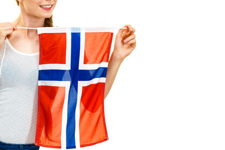 Blonde teenage girl holding flag of Norway. Education. Norwegian language school. Visit Norway concept.の写真素材