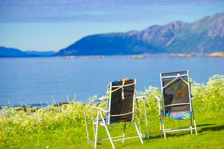 Camping portable chairs and table on norwegian fjord shore. Holidays relaxation on trip. Lofoten Norwayの写真素材