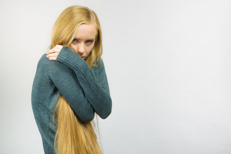 Sad worried young female. Huddled girl feels unhappy, problem in personal life, heartbreak.の写真素材