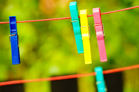 Clips for washing laundry clothes pegs on string rope outdoor. Housework concept