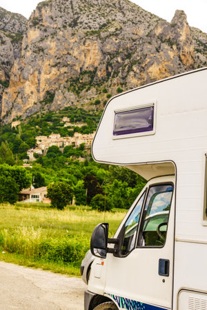 Camper rv and medieval rock village of Moustiers-Sainte-Marie in the distance, Provence in France. European vacation destination.の写真素材