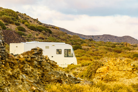 Camper vehicle camping on nature rocky seacoast. Adventure, tour with motor home.の写真素材